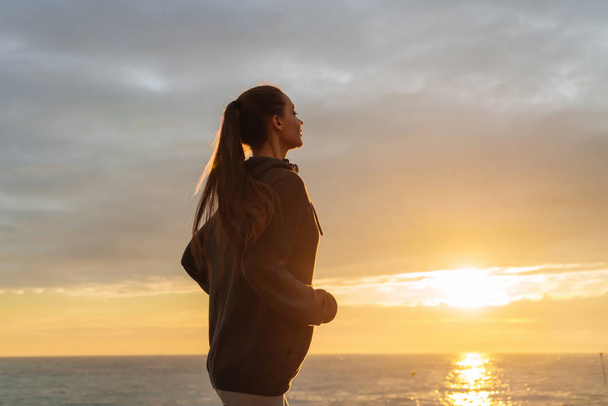 active long-haired girl runs at sunset, wants to lose weight - Fotoğraf, Görsel