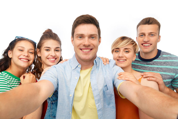 happy friends taking selfie over white background - Фото, изображение