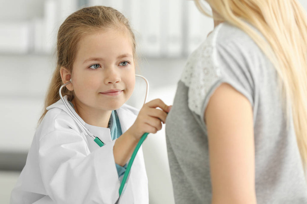 девушка в форме врача осматривает пациента
  - Фото, изображение
