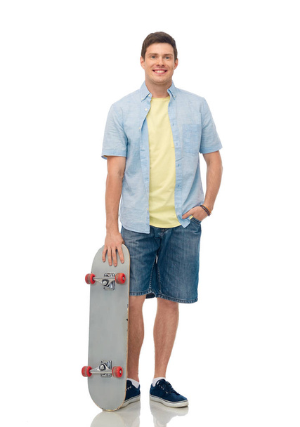 smiling young man with skateboard over white - Valokuva, kuva