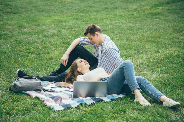 Loving couple students relax after school on the lawn - Foto, imagen