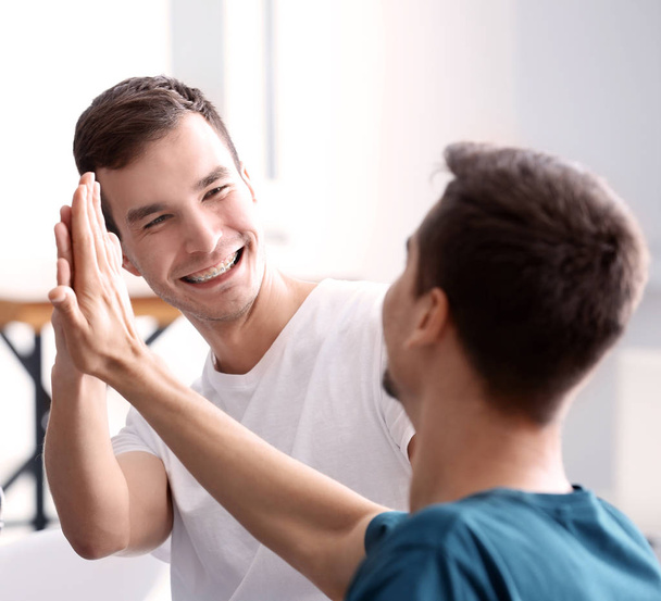 Men giving high five indoors. Unity concept - Photo, image