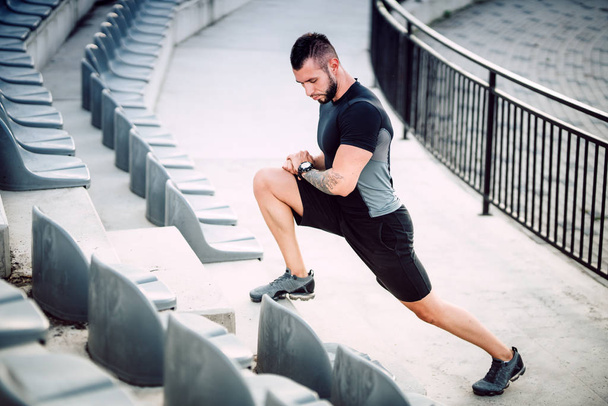 Man doing interval exercises, running and jogging on stadium stairs. Legs and fitness training - Fotografie, Obrázek
