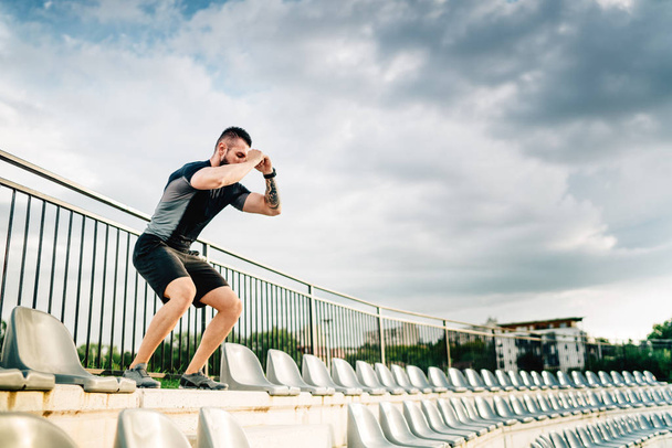 Portrait of active adult working out on stadium stairs, jumping and running - Fotoğraf, Görsel