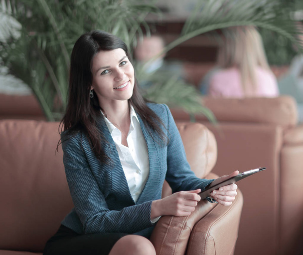 portrait of an Executive business woman with a clipboard on the background of the business center - Photo, Image
