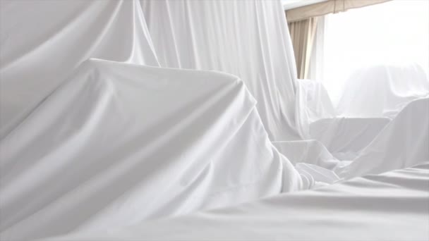 Pano de cobertura de poeira branca cobrindo móveis em uma sala
 - Filmagem, Vídeo