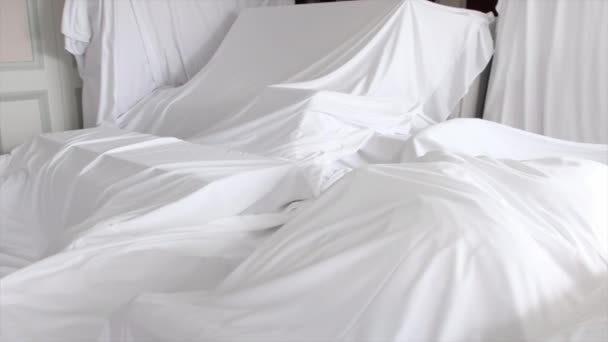 Tkaniny białe osłony przeciwpyłowej obejmujące mebli w pokoju - Materiał filmowy, wideo