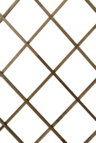 Varillas de madera en una jaula sobre un fondo blanco aislado. La forma de un diamante hecho de varillas de madera
. - Foto, Imagen