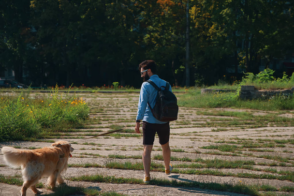 Чоловік гуляє собакою в парку
 - Фото, зображення