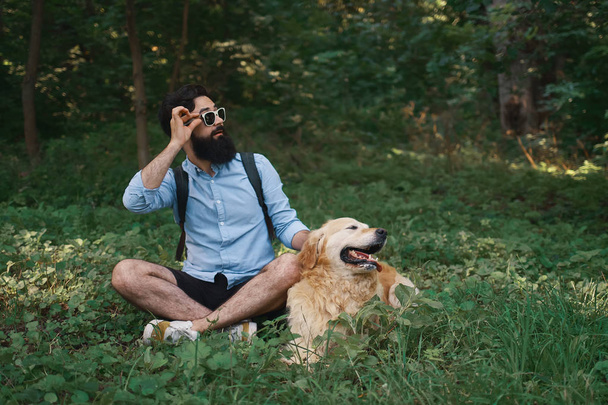 Mies rento vaatteita ja hänen koiransa etsivät yllättynyt vasemmalle
 - Valokuva, kuva