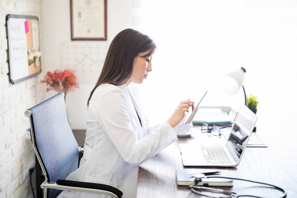 Office dijital tablet üzerinde çalışan kadın beslenme uzmanı yan görünüm. - Fotoğraf, Görsel