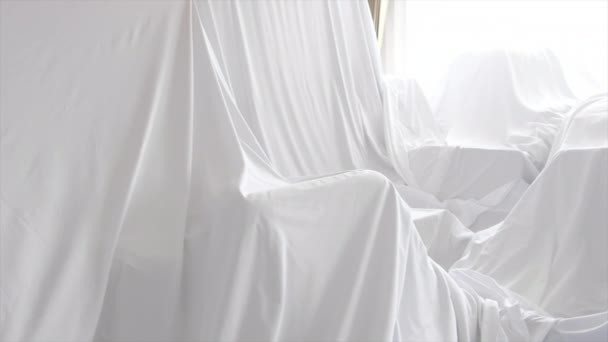 Copertina di polvere bianca che copre mobili in una stanza
 - Filmati, video