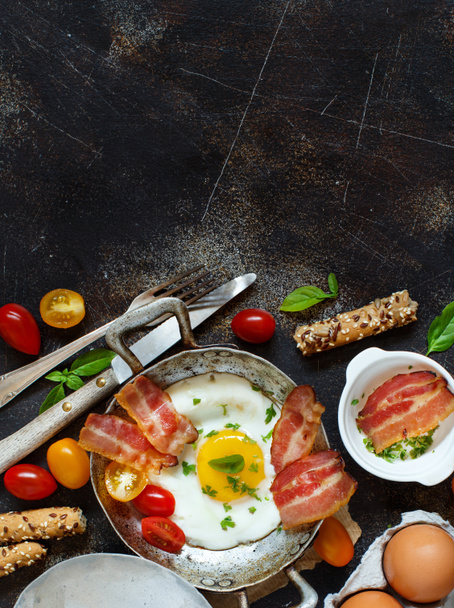 Завтрак с яичницей и беконом в старой сковородке
 - Фото, изображение