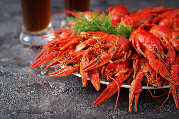 close up of red boiled crayfishes on table with beer glasses - Фото, зображення