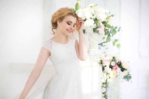 Delicate happy blonde bride in a light interior. - Foto, afbeelding