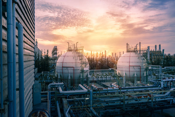 Gas bol opslagtanks en pijpleiding in petrochemische fabrieken op zonsondergang hemelachtergrond, vervaardiging van aardolie-industrie plant - Foto, afbeelding