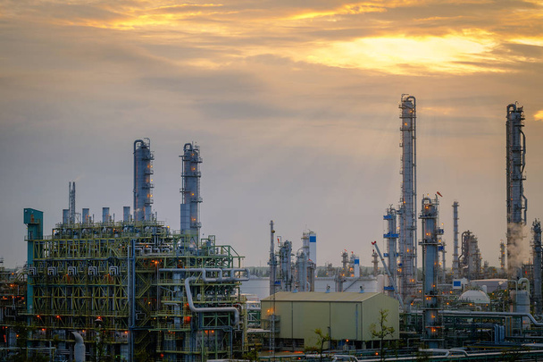 Печі та газопереробна вежа на нафтохімічному промисловому заводі на фоні неба заходу сонця
 - Фото, зображення