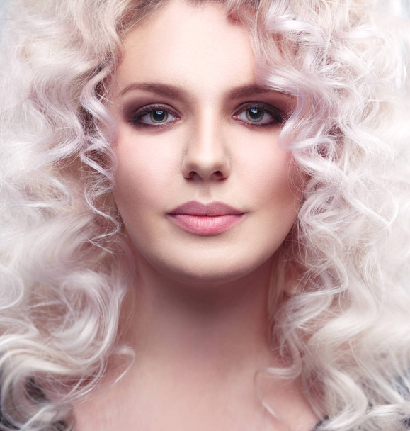 Fashion beauty portrait of a fragile girl gorgeous blonde with a cloud of small curls in pastel colors - Foto, imagen