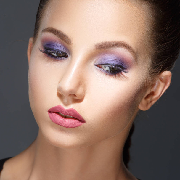 Fashion beauty portrait of a beautiful girl with a lilac make-up isolated on a gray background. - Photo, Image