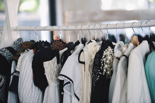 Damenbekleidung auf Kleiderbügeln in einem Boutique-Geschäft - Foto, Bild