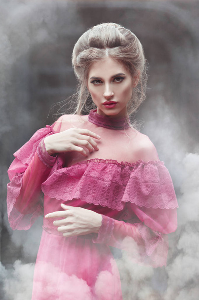 Mysterious portrait of a beautiful woman in a vintage dress in burgundy smoke clubs. - Φωτογραφία, εικόνα
