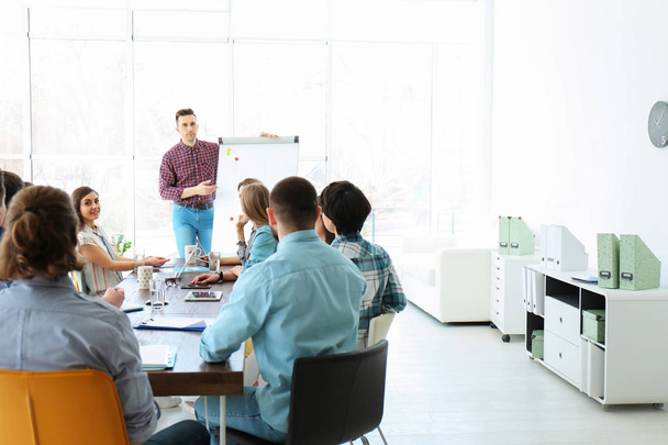 Mannelijke business trainer geeft lezing in kantoor - Foto, afbeelding
