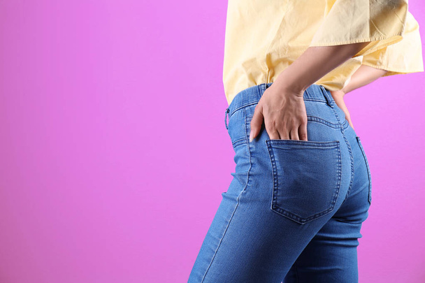 Woman in stylish blue jeans on color background - Foto, immagini