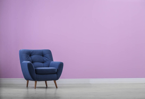 Stylish comfortable armchair near color wall - Zdjęcie, obraz