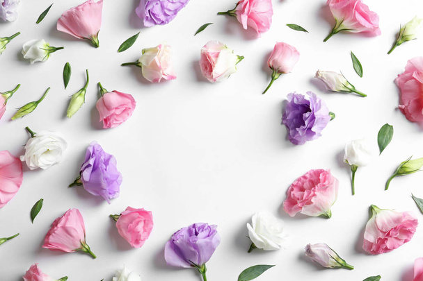 Flat lay composition with beautiful Eustoma flowers on light background - Foto, imagen