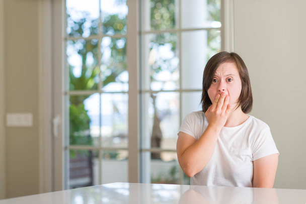 Down syndrome woman at home bored yawning tired covering mouth with hand. Restless and sleepiness. - Photo, Image
