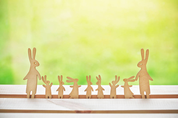 Family of wooden hares with many children. Symbol of happy family and parenthood - Photo, Image