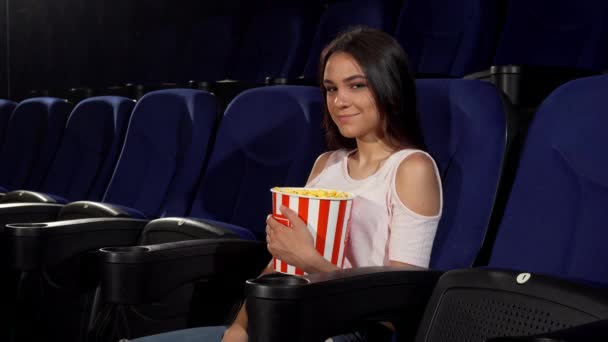 Красива щаслива жінка посміхається до камери в кінотеатрі
 - Кадри, відео