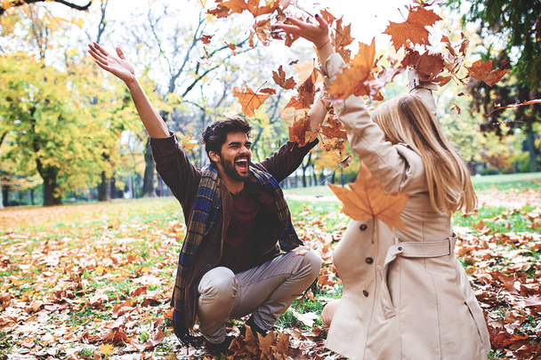 若いカップルが公園で秋を楽しむ. - 写真・画像