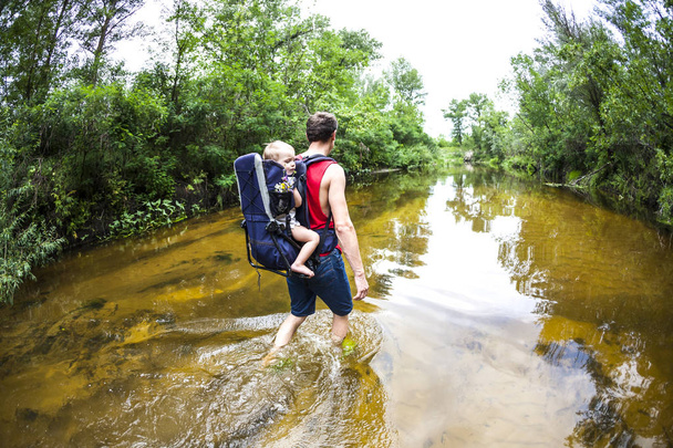 père et enfant longent le lit de la rivière pendant l'inondation en Asie. voyage papa avec un enfant à travers la forêt
. - Photo, image