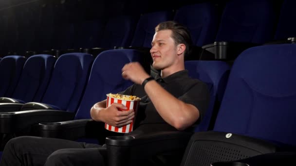 Χαρούμενα όμορφος νεαρός σας προσκαλεί να ζήσουν μαζί του στο σινεμά - Πλάνα, βίντεο