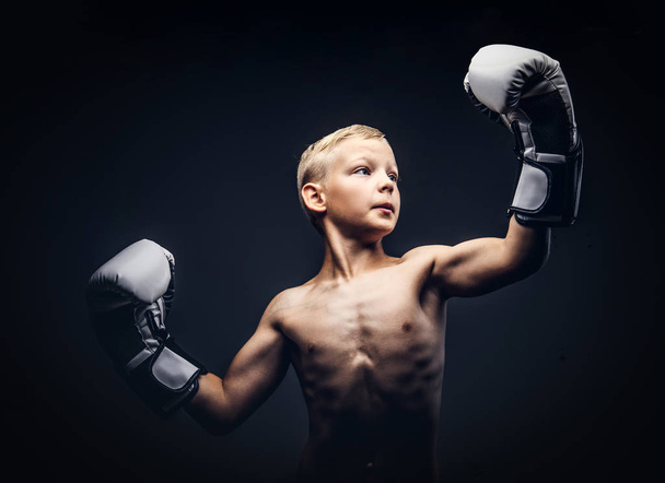 junger Boxer ohne Hemd mit Boxhandschuhen posiert im Studio. - Foto, Bild