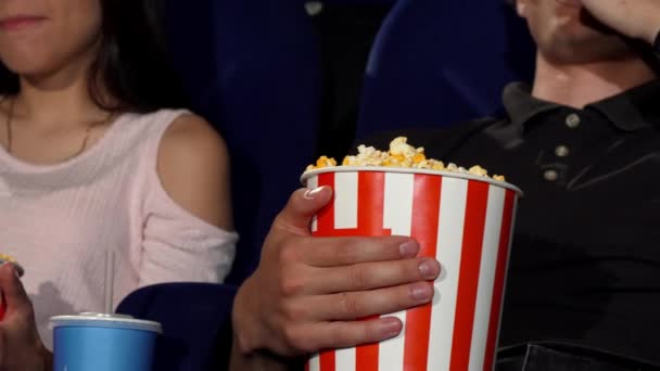 Mężczyzna i kobieta jedzący popcorn w kinie - Materiał filmowy, wideo