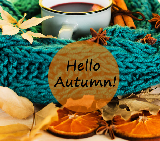 Autumn, fall leaves, hot steaming cup of glint wine and a warm blue scarf on wooden table background. Seasonal, autumnal hot wine, Autumn relaxing and still life concept with text hello autumn. - Fotografie, Obrázek