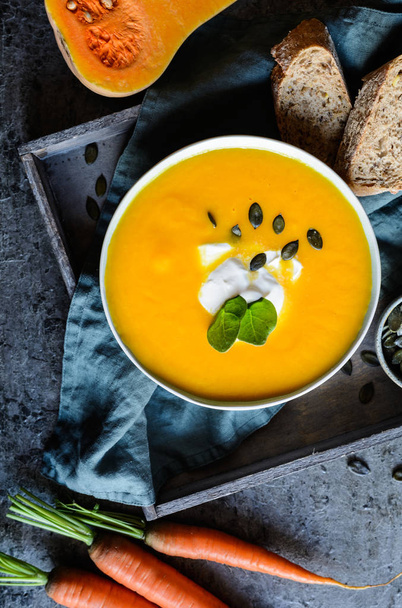 Sopa de abóbora e cenoura tradicional com creme azedo
 - Foto, Imagem