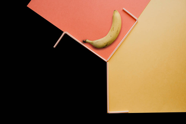 Uma fotografia criativa com uma banana e pequenos tubos sobre um fundo brilhante
 - Foto, Imagem