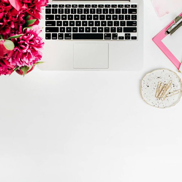 Lapos laikus workspace-val laptop, a tartozékok és a pünkösdi rózsa csokor virág a fehér háttér előtt. Felülnézet blog hős fejes. - Fotó, kép
