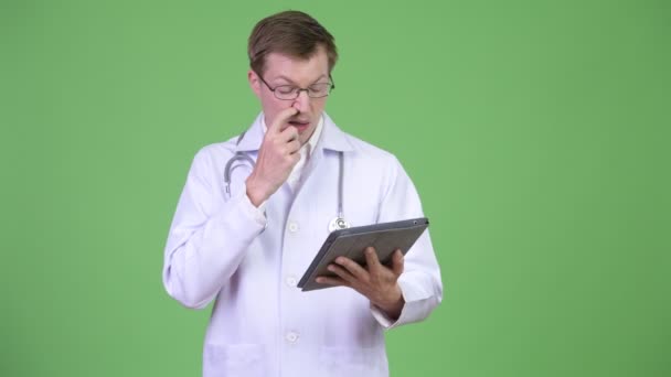 Ekelhafter Mann Arzt furzt und pflückt Nase mit digitalem Tablet - Filmmaterial, Video