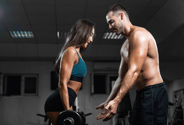 Man instructor and woman train in the gym, lifting dumbbells - Foto, immagini