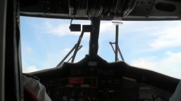ウィンドウの背景に飛行機のコックピットに 2 人のパイロットの背中からの眺め. - 映像、動画