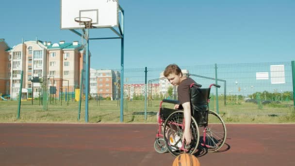Homem com deficiência joga basquete de sua cadeira de rodas, ao ar livre
 - Filmagem, Vídeo