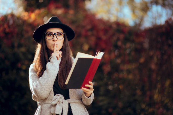 Hipster Student Holding a Book Outdoors in Autumn Decor - Fotó, kép
