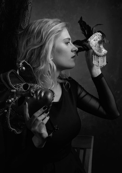 Retrato de bela jovem mulher em vestido preto com máscaras de carnaval. Preto e branco
. - Foto, Imagem
