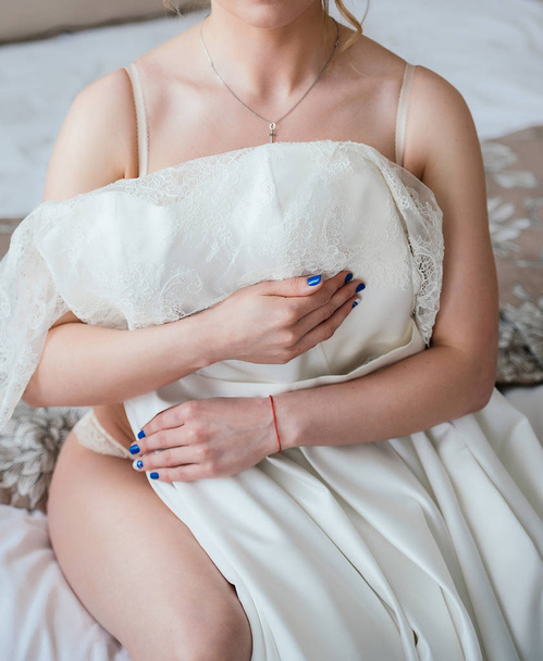 ランジェリー ベッドの上に座って、ウェディング ドレスの美しい花嫁。結婚式前に花嫁の朝。ベージュの下着の美少女モデル。ベージュのランジェリーのベッドの上で魅力的なセクシーな女性の肖像画 - 写真・画像