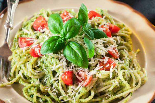 Vegetarian pasta spaghetti with basil pesto and cherry tomatoes. Italian dish. Top view - Foto, Imagem