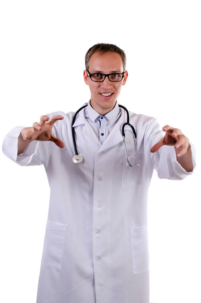 der Arzt in weißem Mantel und Brille greift einen imaginären Gegner an, um ihn zu erdrosseln, während er auf weißem Hintergrund lächelt - Foto, Bild